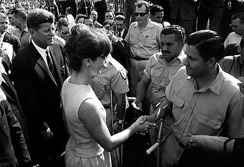 President Kennedy and Jacqueline Kennedy shaking hands with members of Brigade 2506 in a crowd.