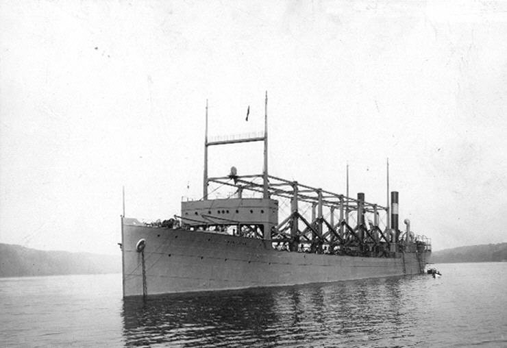 The large Navy collier USS Cyclops anchored in the Hudson River, with tall cranes on deck.