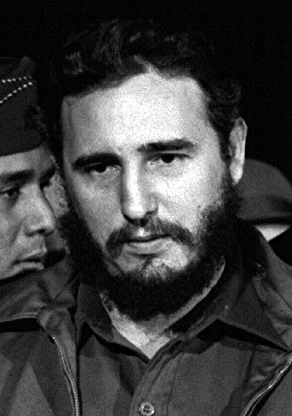 A close-up black-and-white photo of a bearded Fidel Castro in 1959.